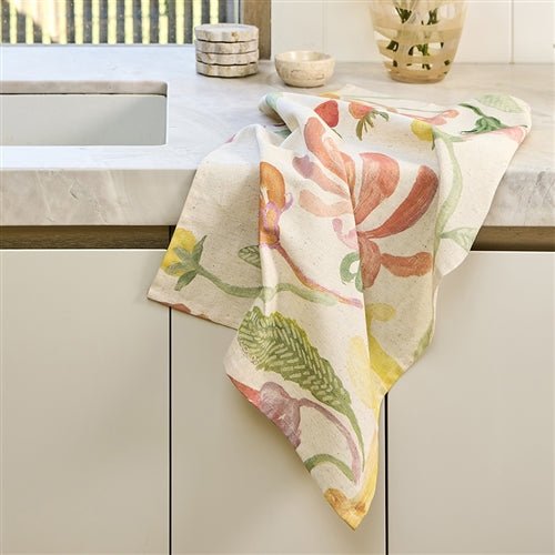 Floral patterned dish towel hanging on a kitchen cabinet