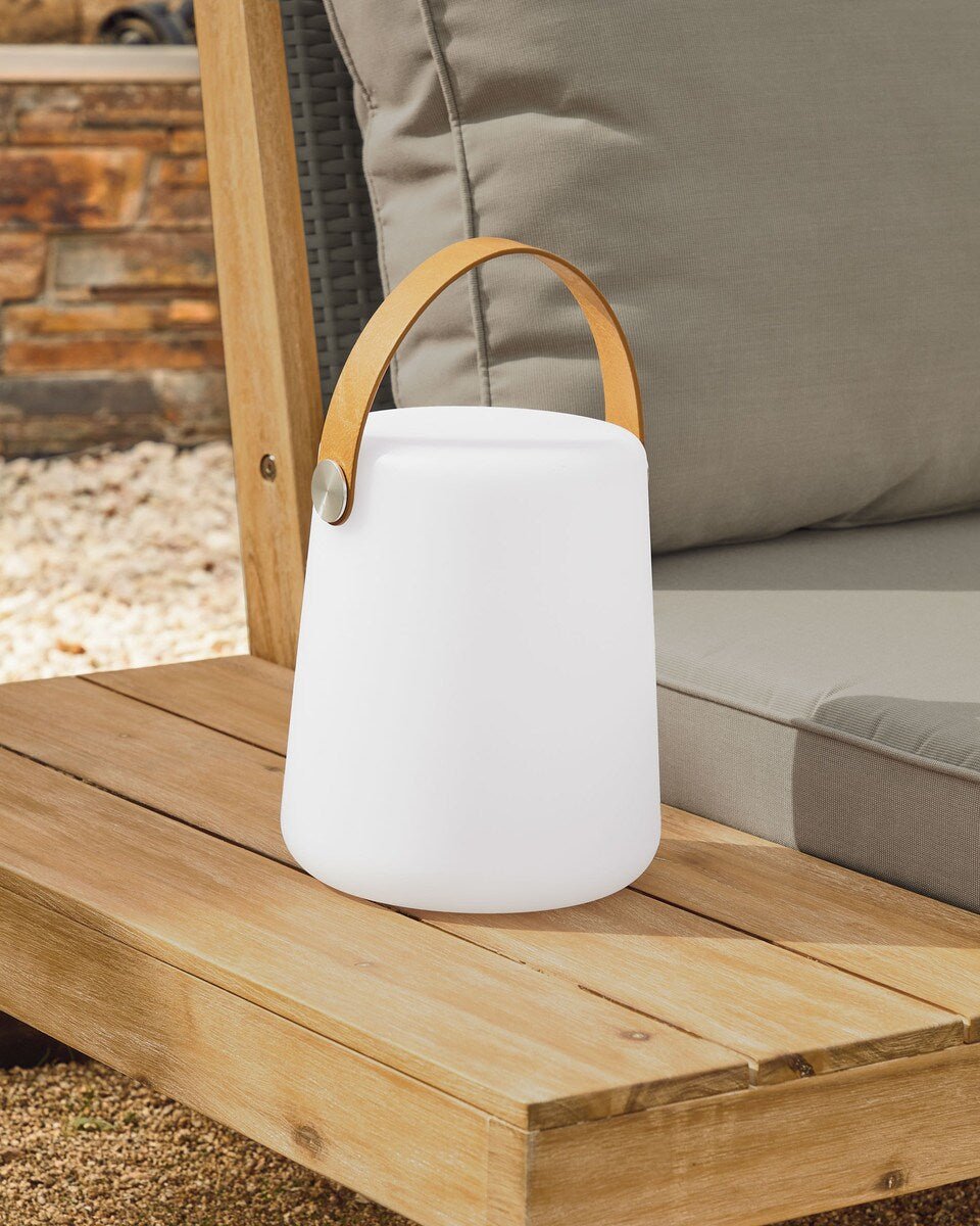 White outdoor lantern with a wooden handle on a wooden surface