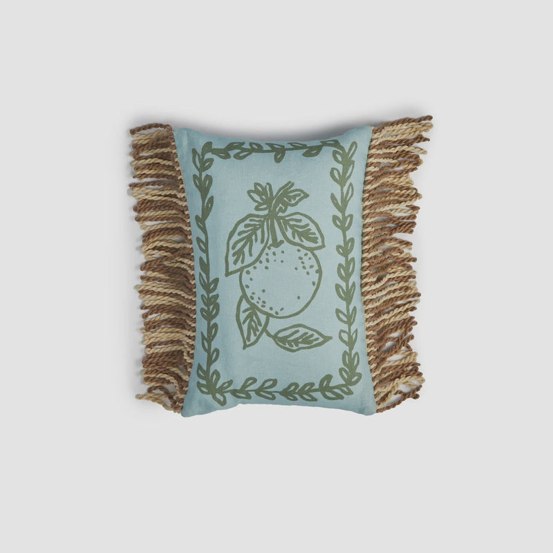 Decorative pillow with fringe and leaf pattern on a light gray background